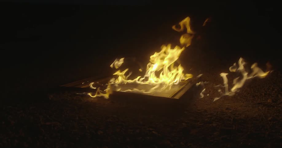 Fire burning a wooden object in the night