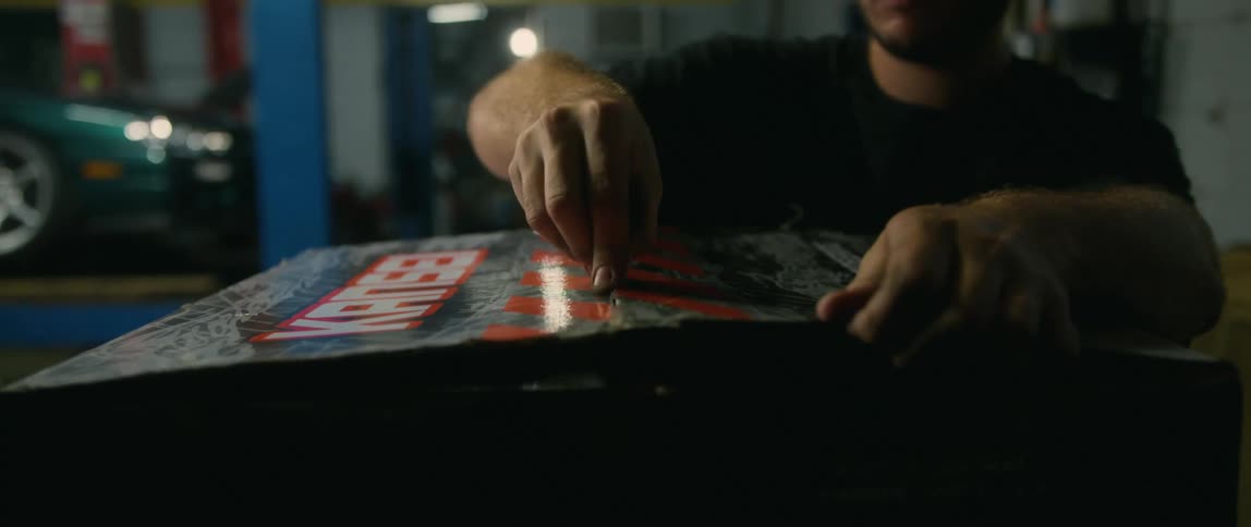 A man opening a box in a garage