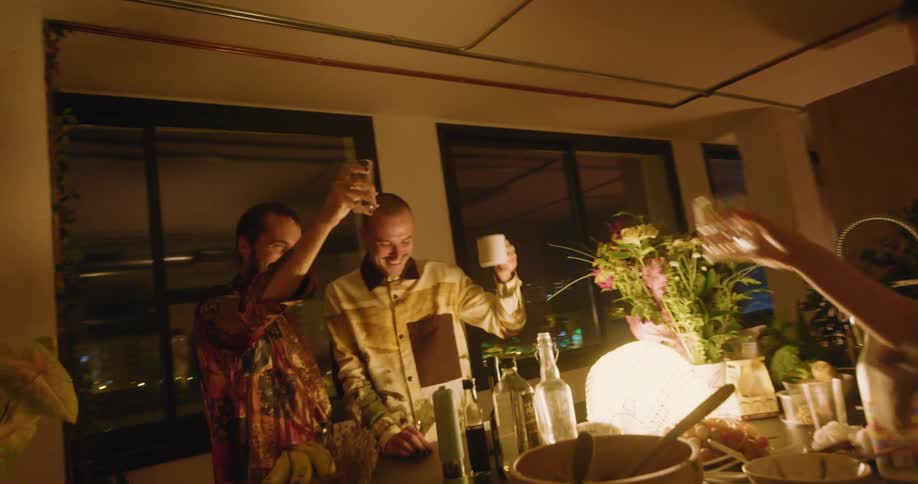 A group of friends drinking in a kitchen