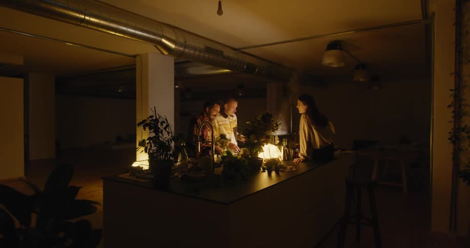 A group of people standing around in a kitchen together