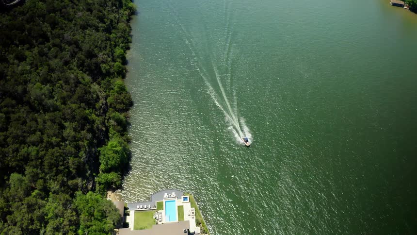 An aerial view of a boat traveling down a river