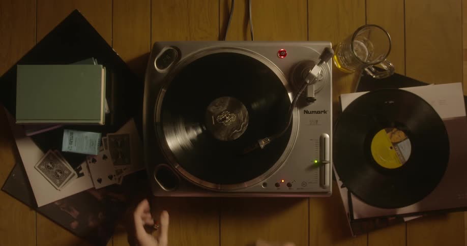 Person plays a record on a record player