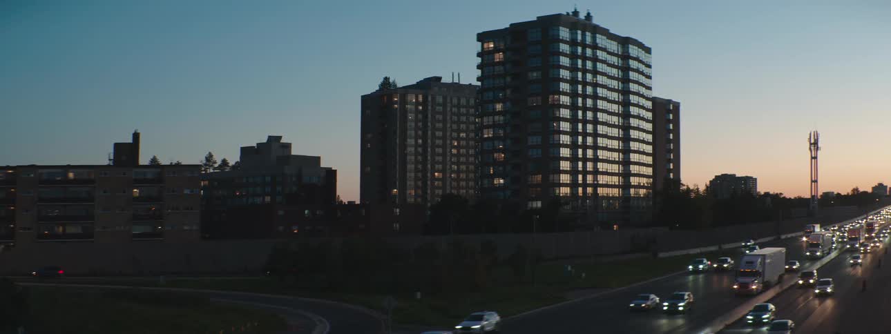 Cars and trucks are traveling on a city freeway at night