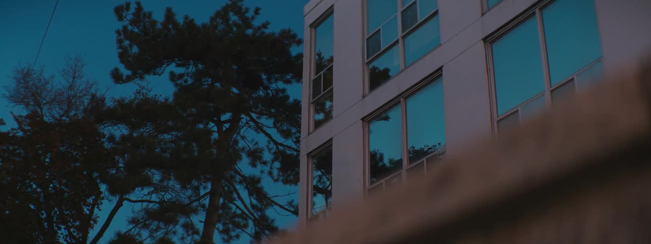 A building in a city at dusk as seen from low to the ground
