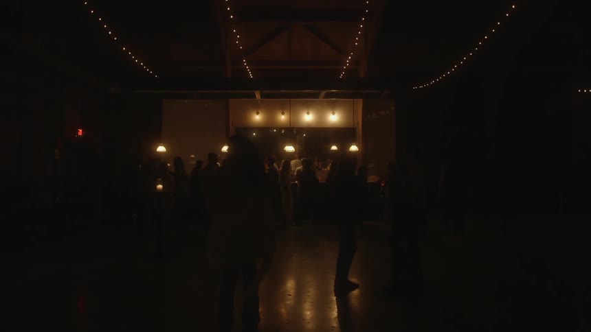 A group of people are standing outside at night