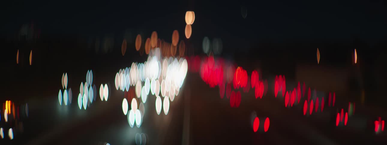 Blurred headlights of vehicles traveling on a highway at night