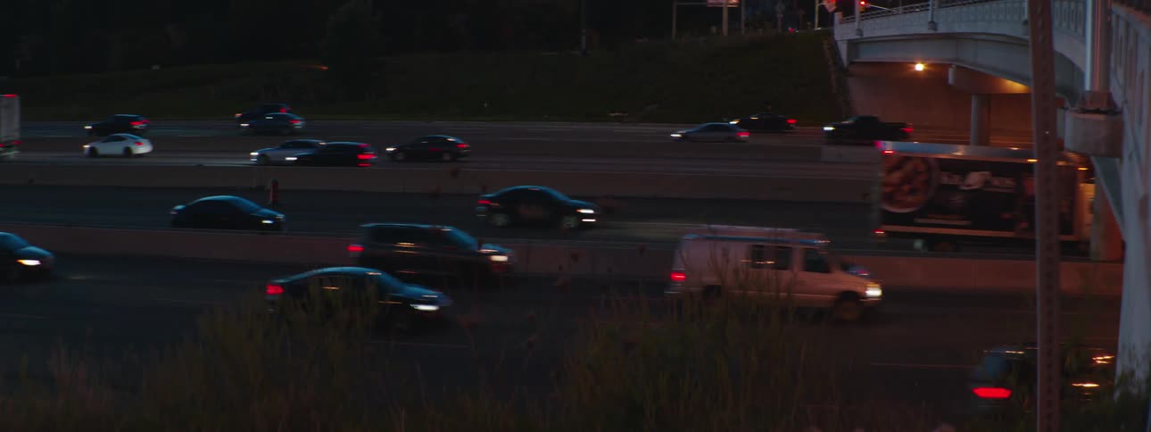 Bumper to bumper traffic drives under a highway overpass