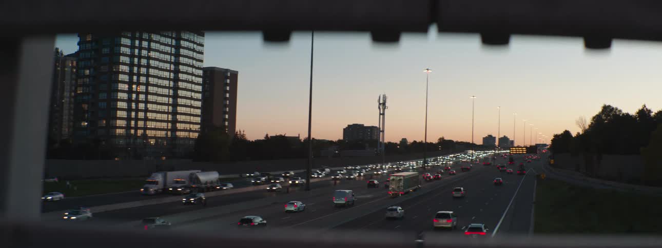 Traffic traveling on a multi lane highway in both directions viewed from an overpass