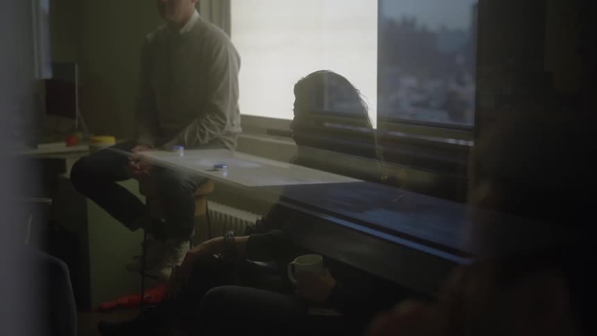 People are sitting behind glass in an office