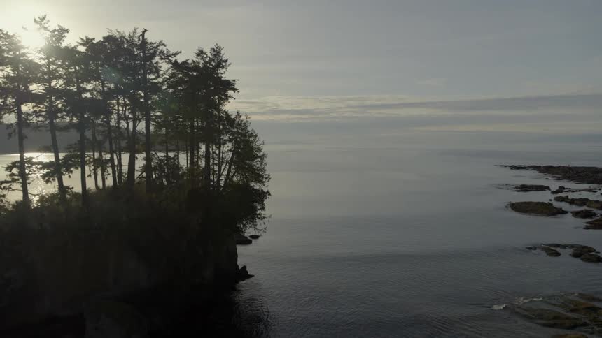 Reveal of extremely calm ocean water beyond natural rock formations along a rugged coastal shoreline