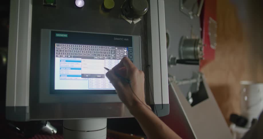 A woman uses a stylus to enter data into a machine using a touch screen panel display