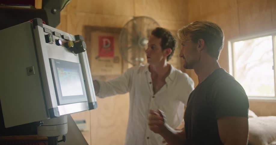Two men chat as they examine a large piece of equipment