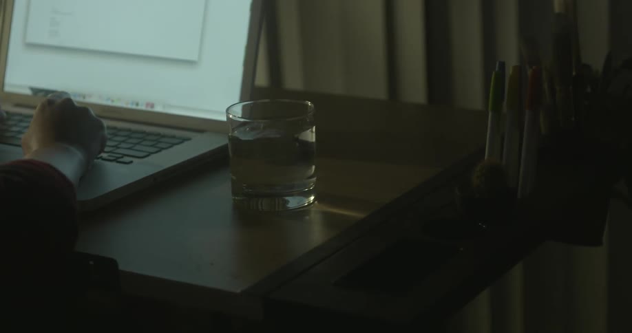 A person is using a laptop as the water on the table shakes