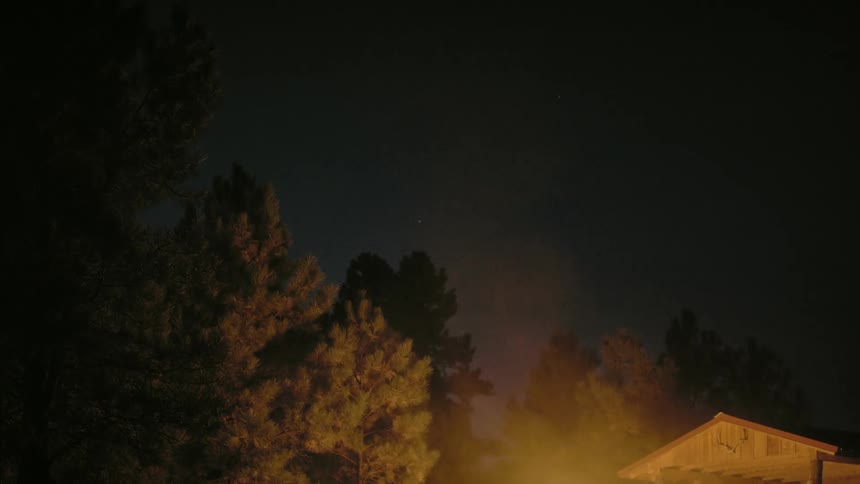 Bonfire in front of a house in a rural area near the forest at night
