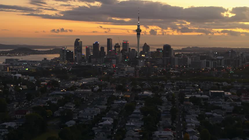 Aerial view of the skyline of a waterfront city at sunset