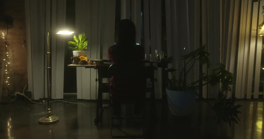 A person is sitting at a desk in a dark room