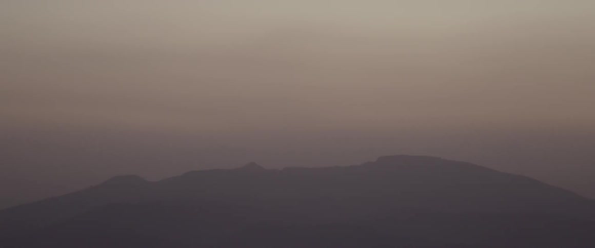 A foggy area has hills in the distance
