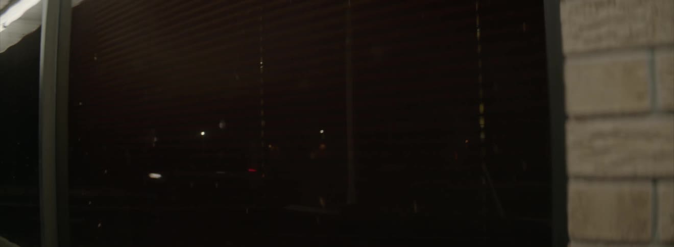 Reflection in a window of cars driving by at night