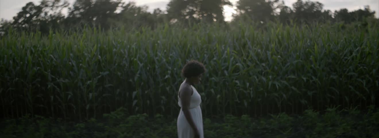 Woman standing outside by a corn field