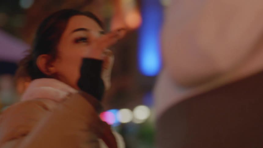 A woman high fives her friend as they stand downtown
