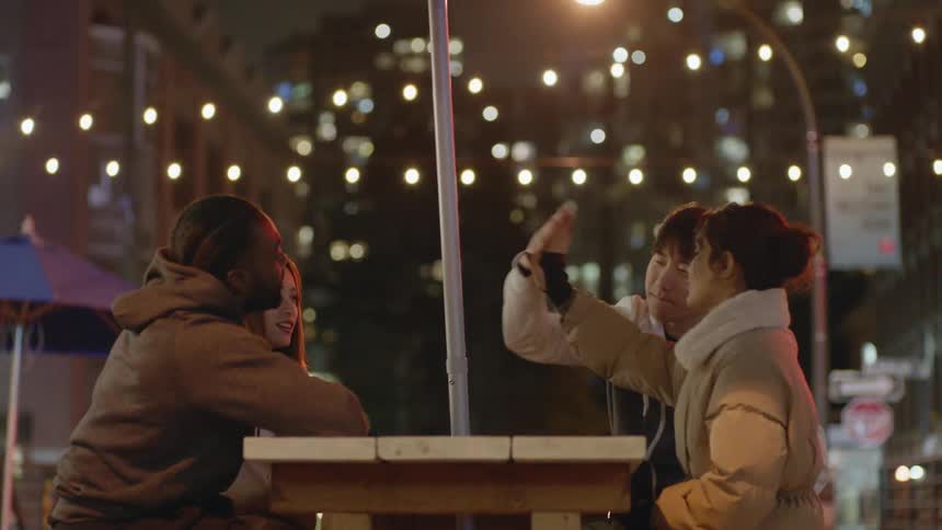 A group of friends talking and sitting outside together