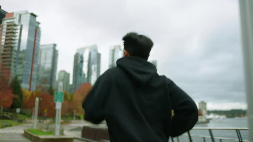 A man jogs on the trail by the shore of the city