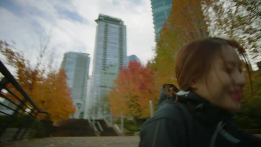 Woman sitting on the stairs near the city stands up and starts jogging with a friend