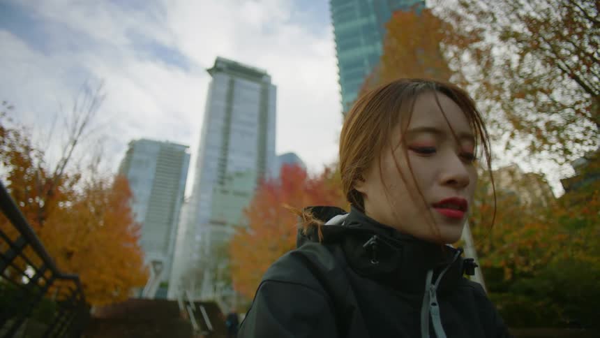 Asian female sitting down outdoors