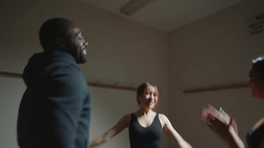 Group of friends clapping and celebrating on a dressing room