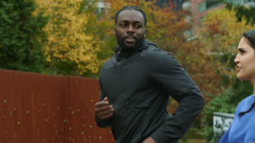 A man and two women are jogging together