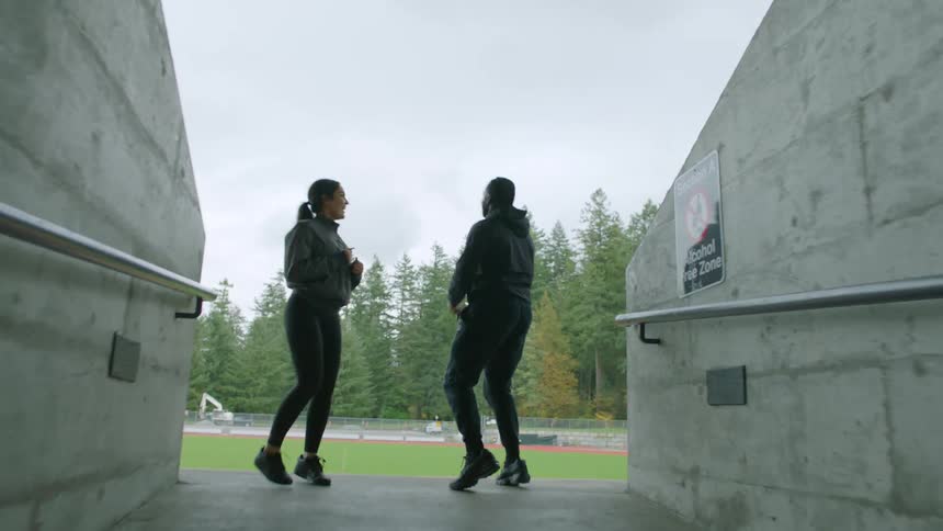 A man and woman jog to the running track