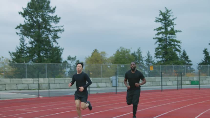 Friends jogging on a running track next to the city