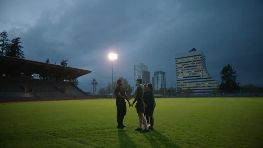 Four people talk together on the field