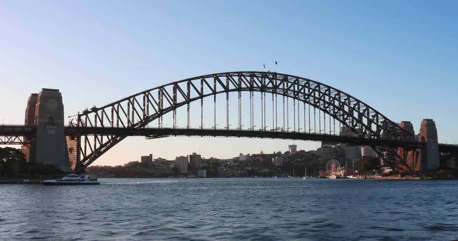 A large bridge between sections of land on the coast of a city during the day