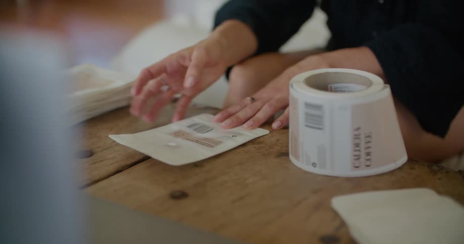 Woman palces stickers on cards over the coffee table in the living room