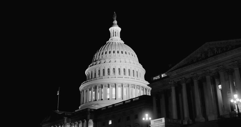 The dome of the capitol building at night with the lights on