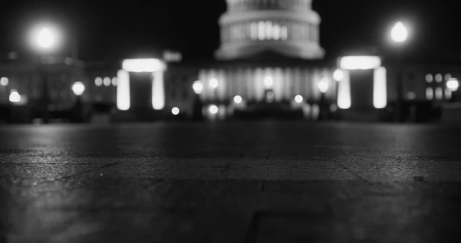 Black and white close up of the sidewalk in front of the capitol building at night