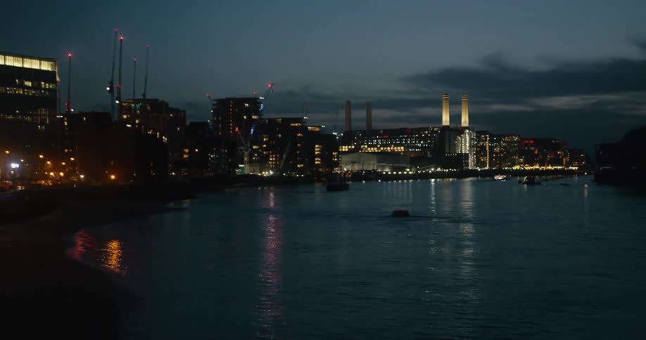 The lights of Battersea and London glow and reflect in the water of the River Thames