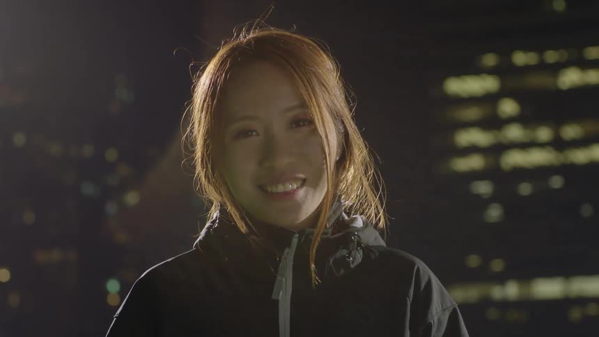 A woman poses at night