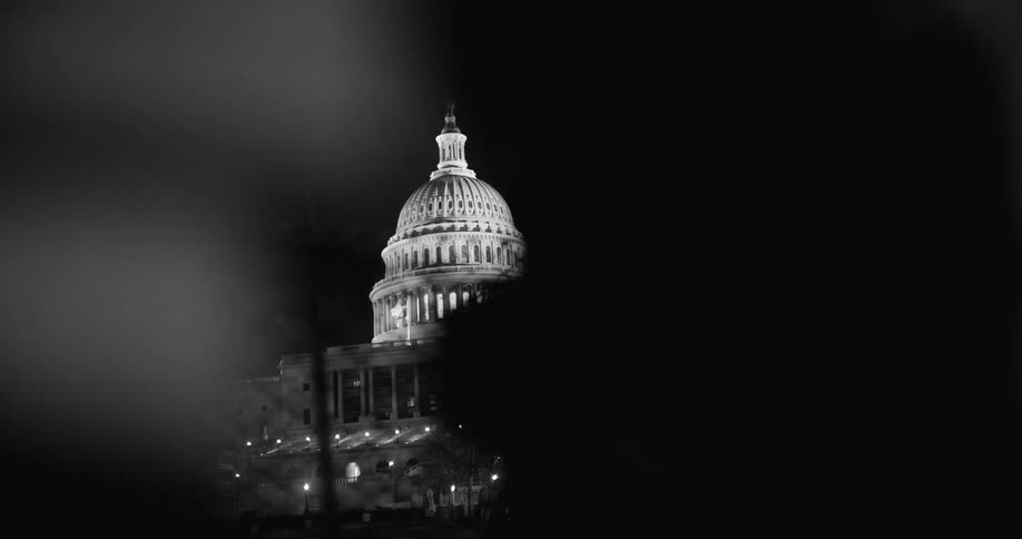 A glowing domed government building at night