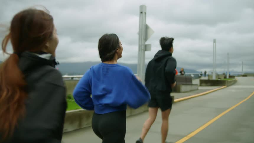 Friends run on the track on a cloudy day