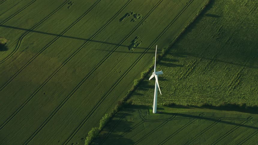 White turbines in a green field on a sunny day
