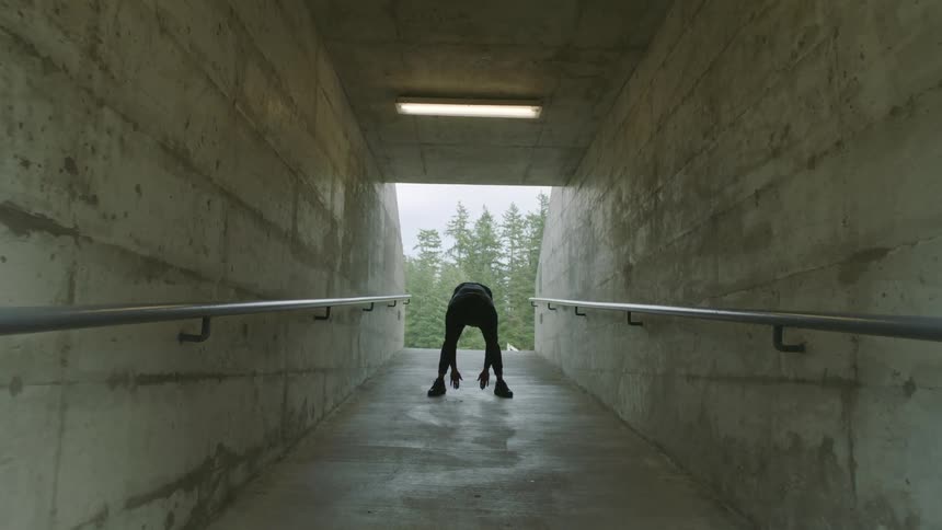 A man stretches and exercises inside a walking tunnel