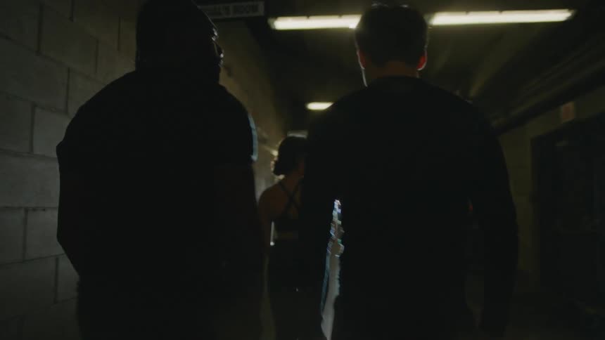 A group of people walk together through a dimly lit corridor