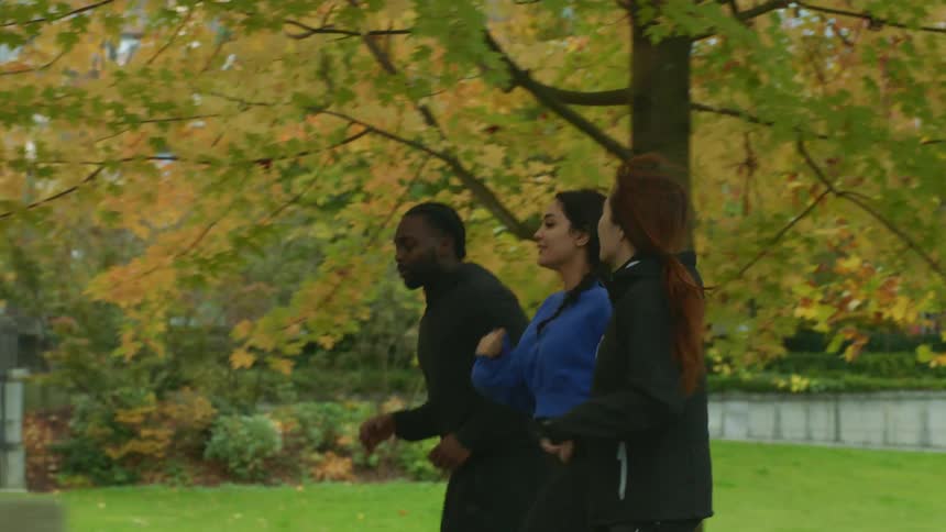 Group of friends jogging in the park next to the city