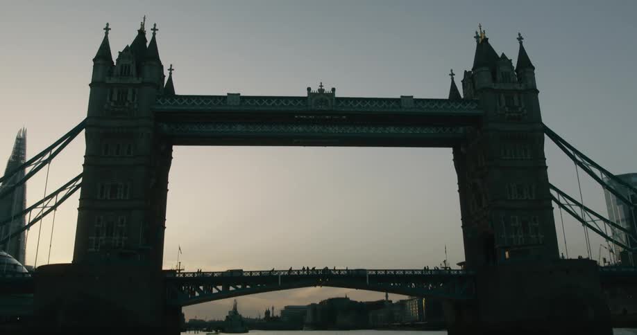 Two towers of London's tower bridge at sunset from River Thames