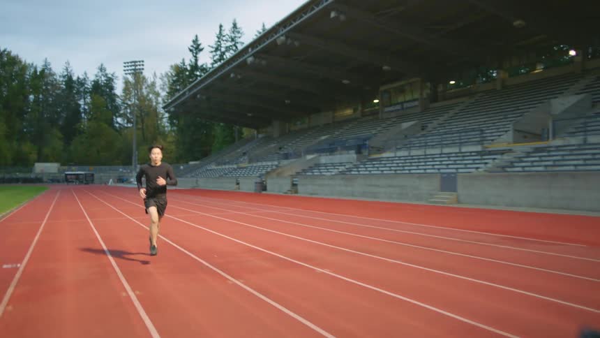 Two friends wearing black clothes running on a race track