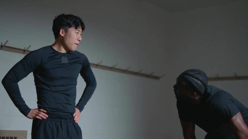 Two men fist bump as they take a break from working out