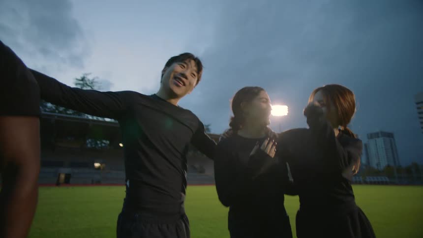 Four friends huddle up on the field