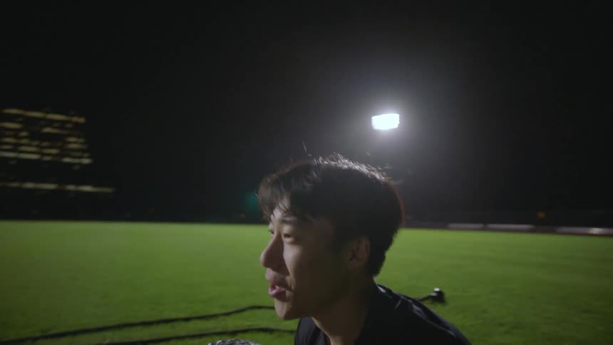 Group of friends exercising together on a field near the city at night